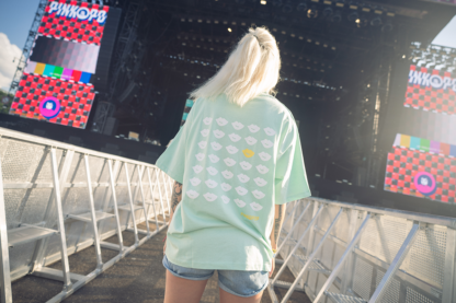 Vrouw met groen shirt, opdruk met wit en geel op rug.